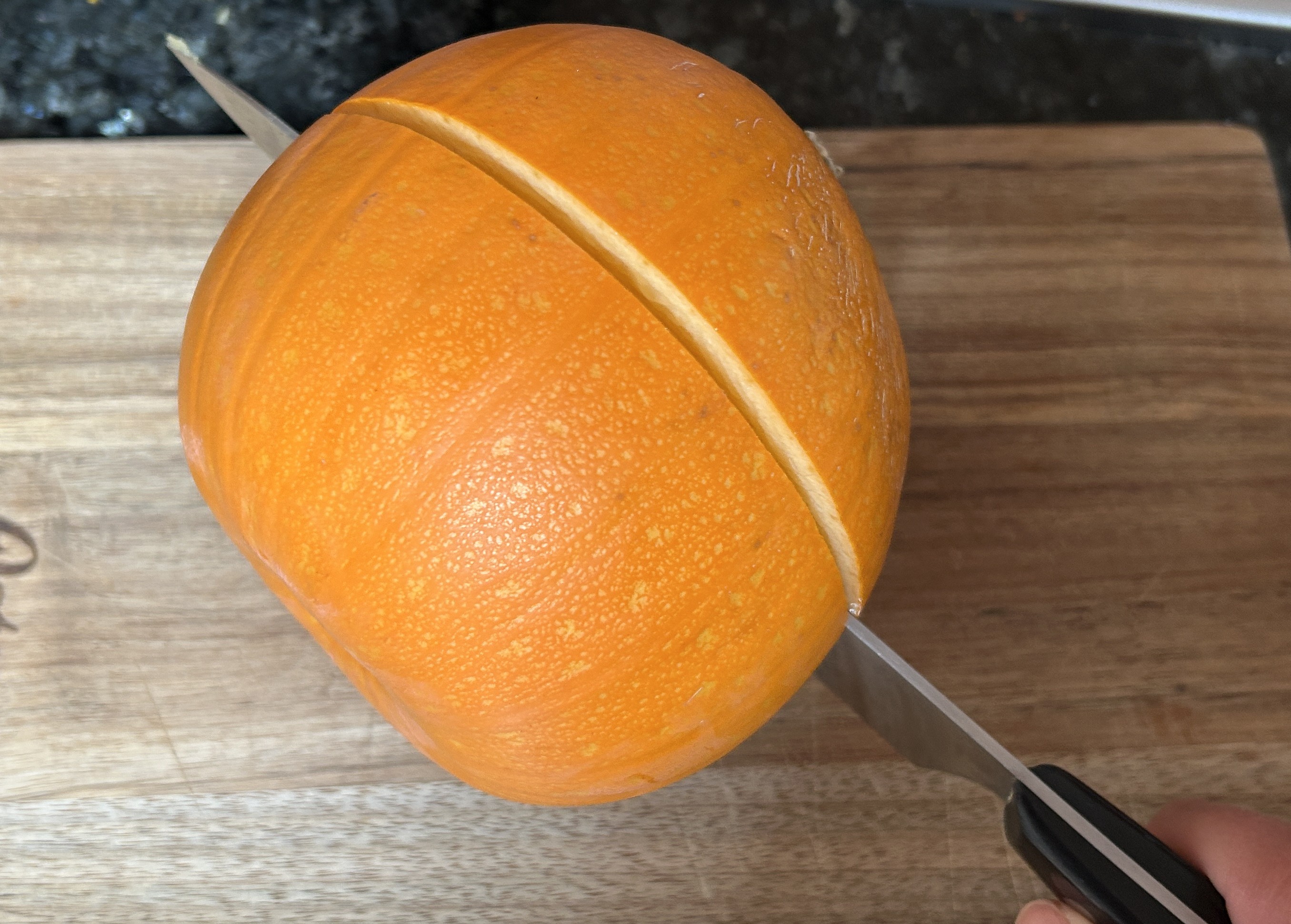 slicing a pumpkin in half to make puree