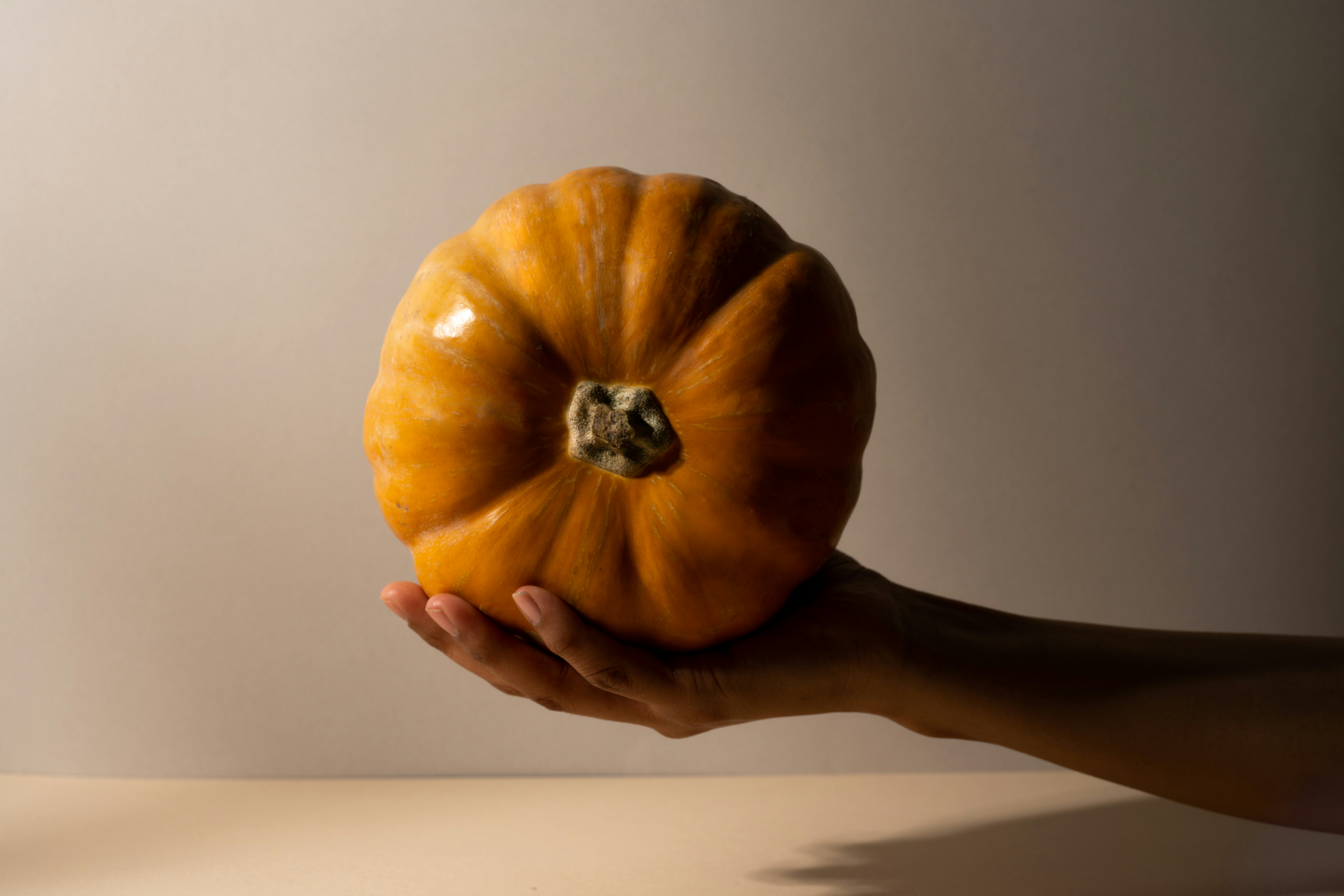 A pumpkin being held up 