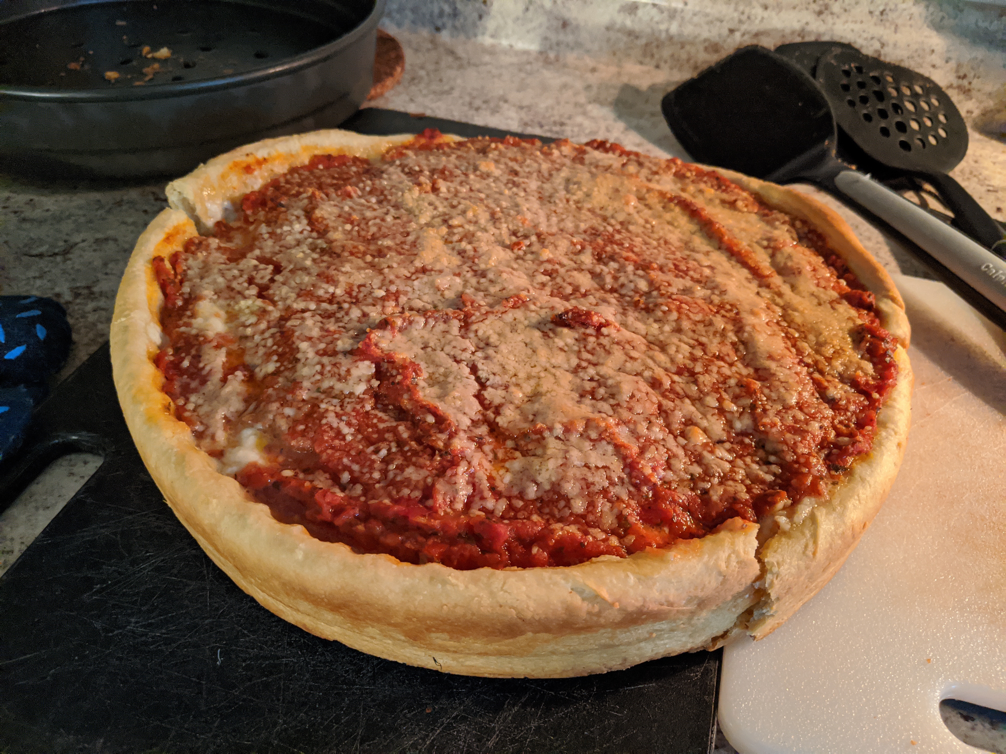 A deep dish pizza on a cutting board