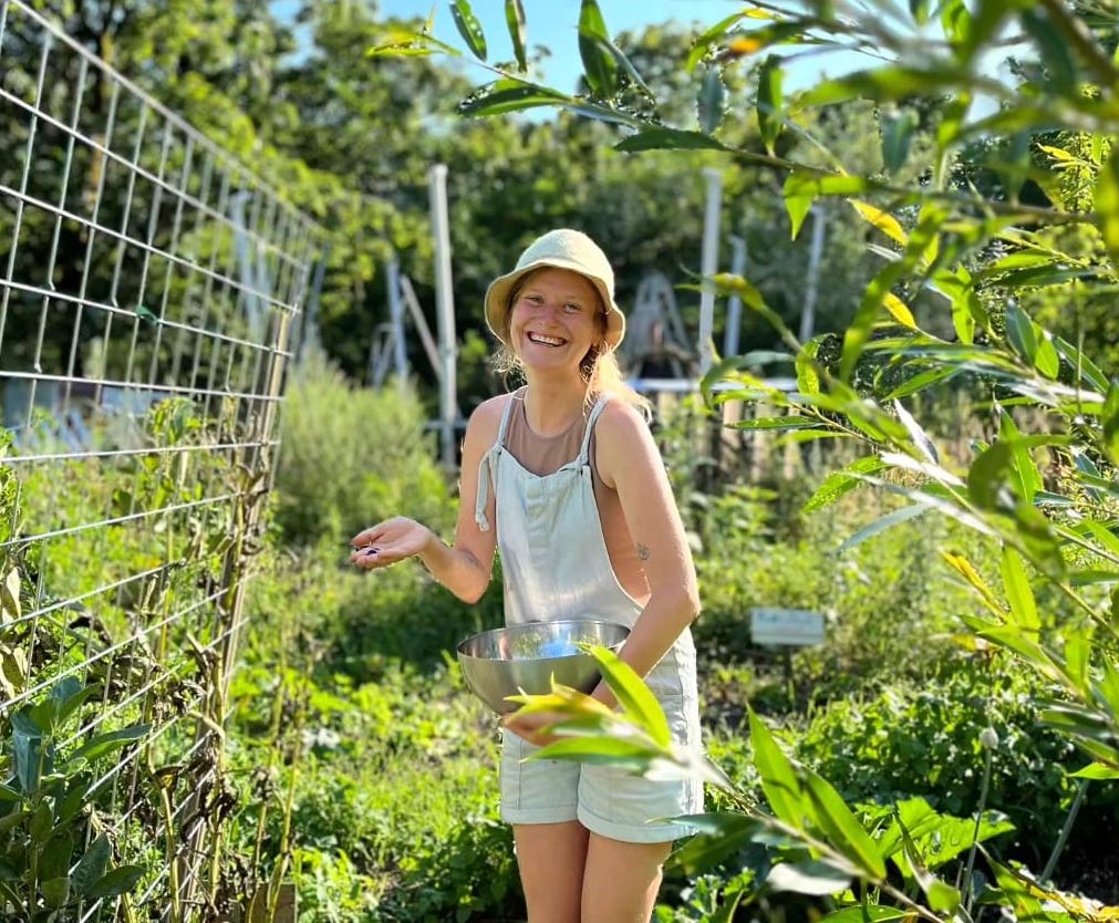 Author Sarah-Manon, all smiles while harvesting broad beans.