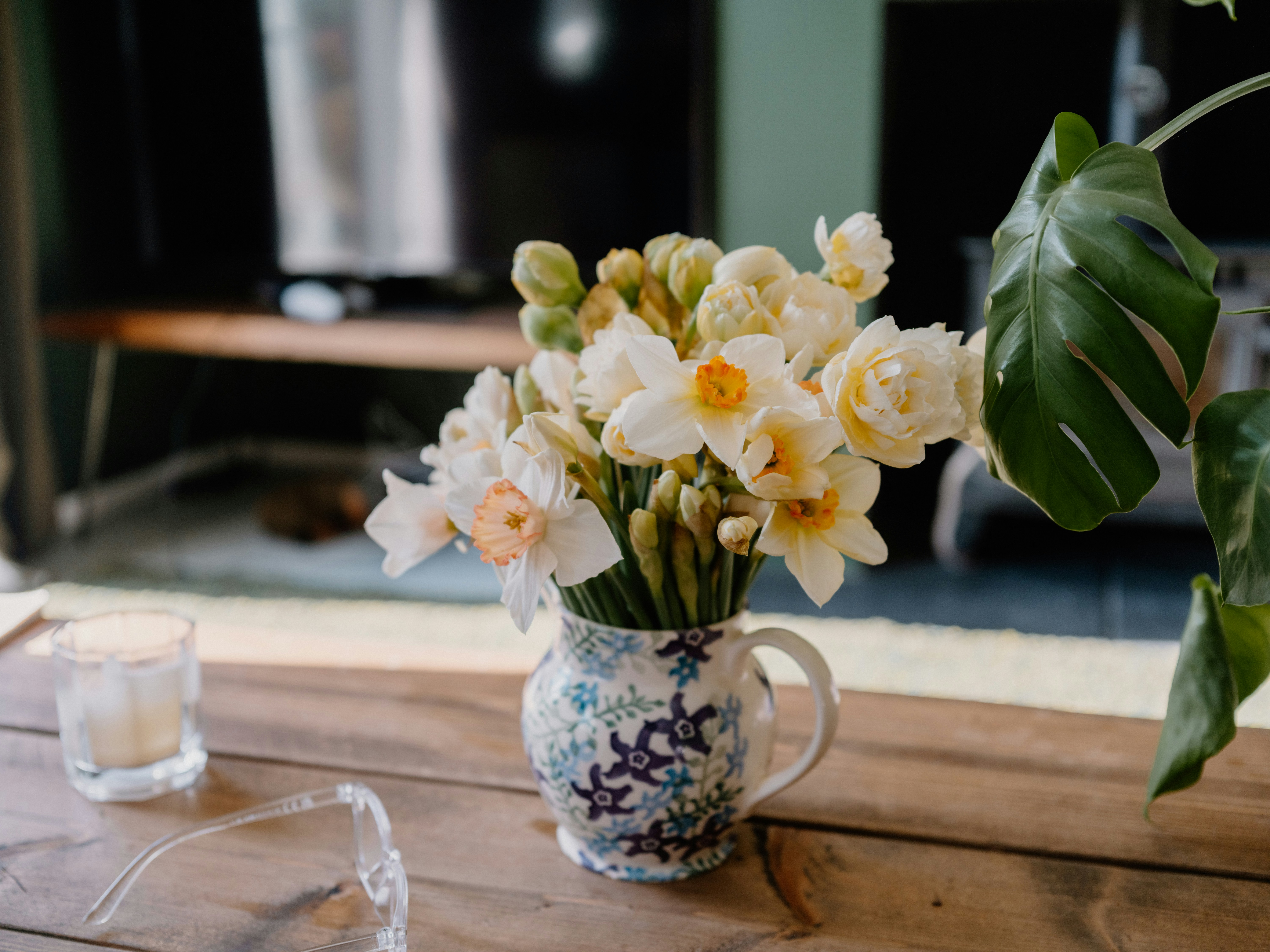orange and white daffodils in a mug
